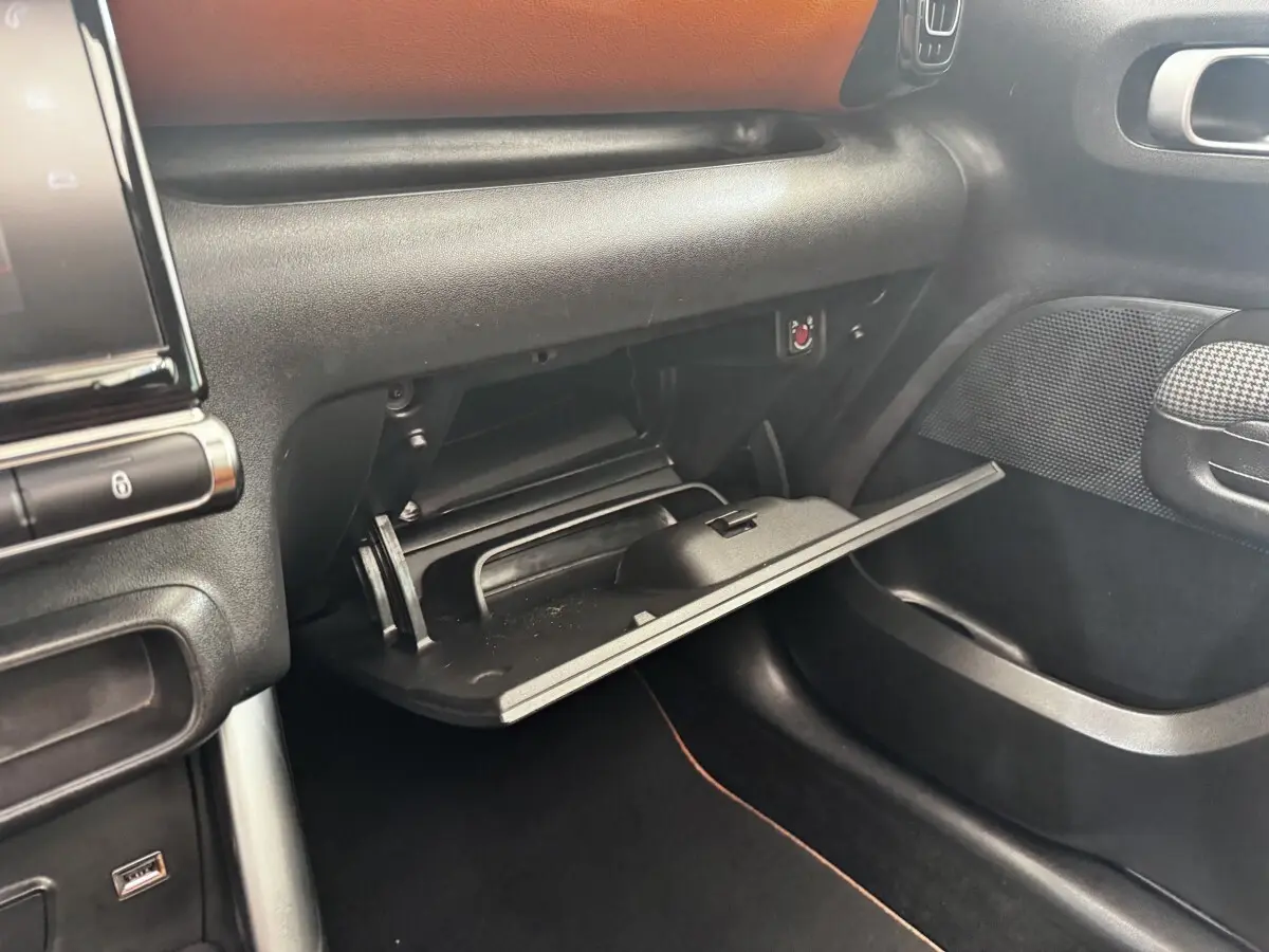Vue intérieure côté passager du coffre à gants ouvert dans une Citroën C3 Aircross noire de 2020.