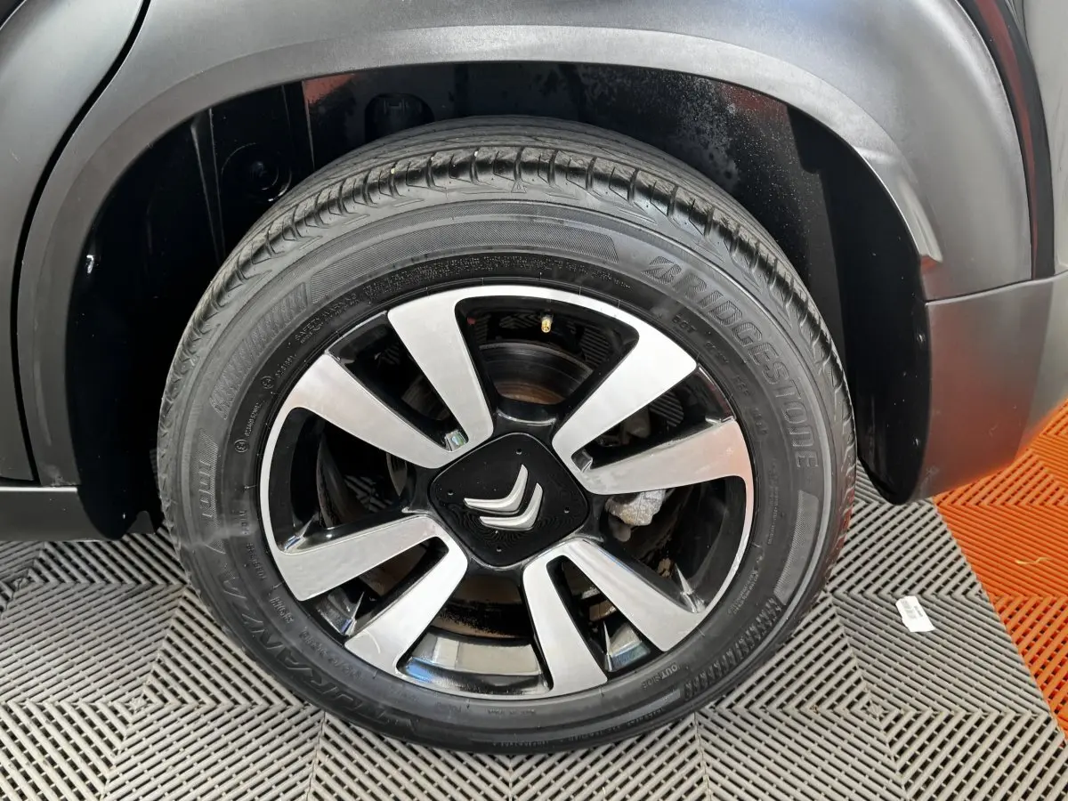 Gros plan sur la roue avant droite noire avec jante alliage bicolore du Citroën C3 Aircross 2020.