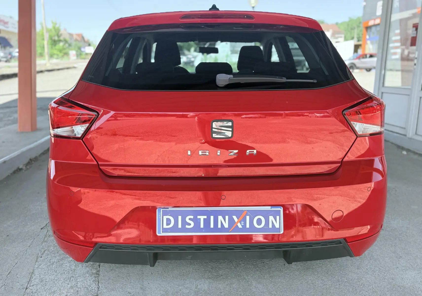 Vue arrière d'une SEAT Ibiza rouge passion métal, mettant en valeur son hayon et ses feux arrière anguleux.