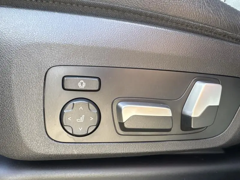 Détail des commandes électriques du siège avant gauche du BMW X3 xDrive30e 2023 en Saphirschwarz métallisé.