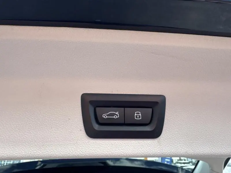 Boutons de commande pour coffre électrique et verrouillage, situés sur le hayon intérieur d'un BMW X3 xDrive30e 2023 noir.