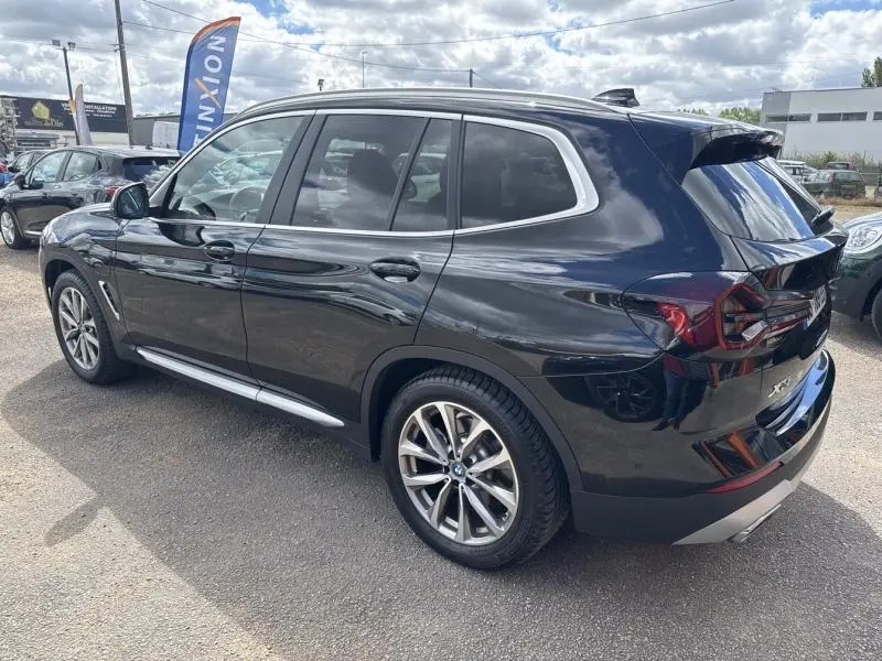 BMW X3 xDrive30e 2023 en Saphirschwarz métallisé, vue 3/4 arrière droit avec jantes alliage et toit panoramique.