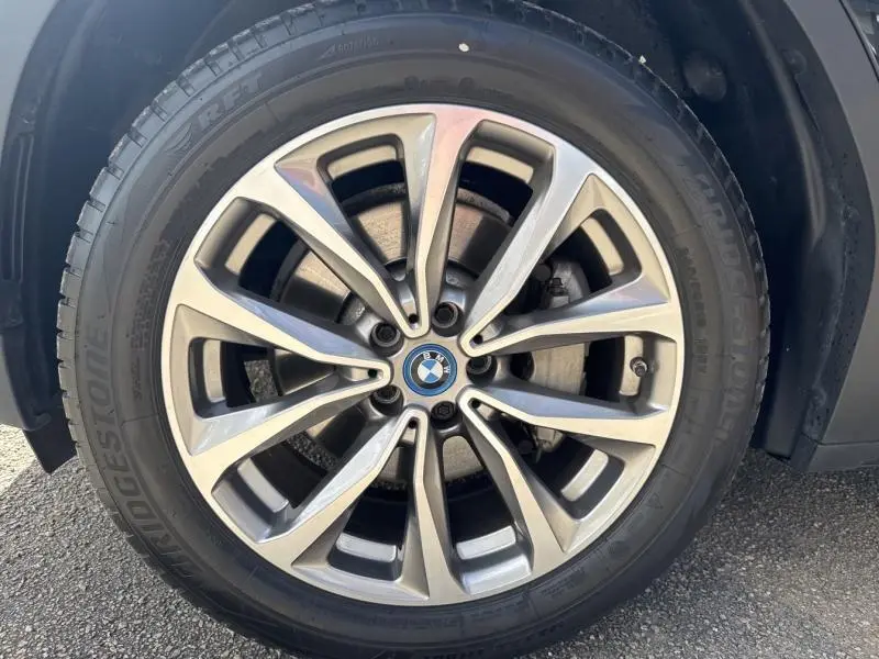 Gros plan sur la jante alu 19 pouces style 692 d’un BMW X3 xDrive30e Saphirschwarz métallisé.
