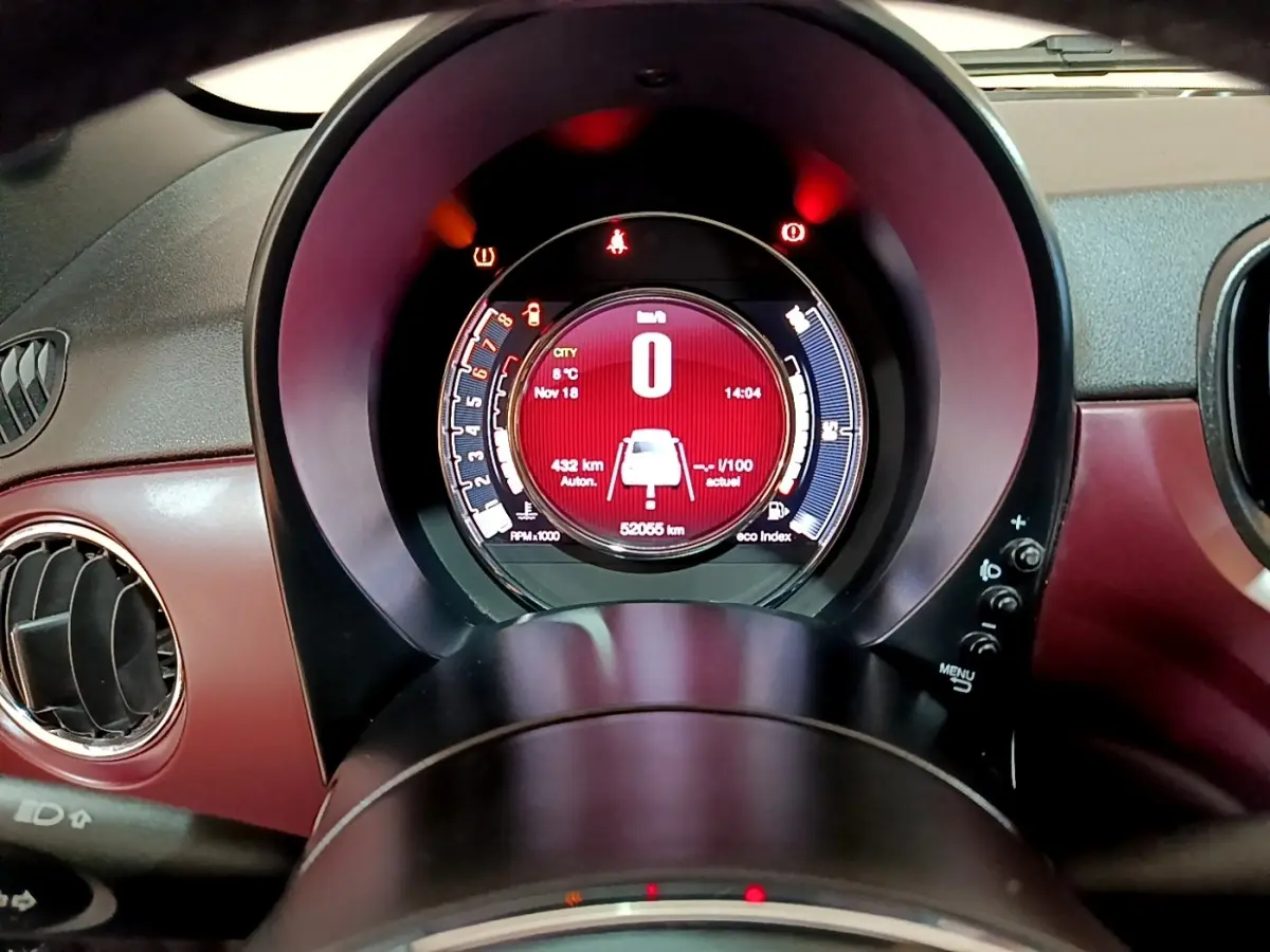 Vue rapprochée du tableau de bord rouge de la Fiat 500 1.0 70ch BSG Star avec affichage digital central lumineux.