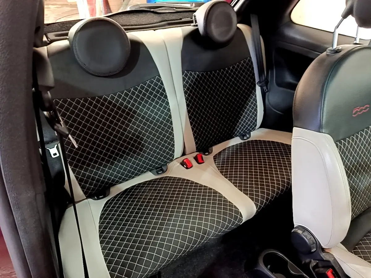 Vue intérieure sur la banquette arrière et siège avant de la FIAT 500 avec sellerie noire et beige à motifs losanges.