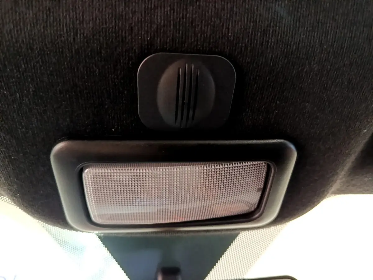 Plafonnier intérieur noir avec bouton de commande, vue en contre-plongée dans une Fiat 500 rouge 2021