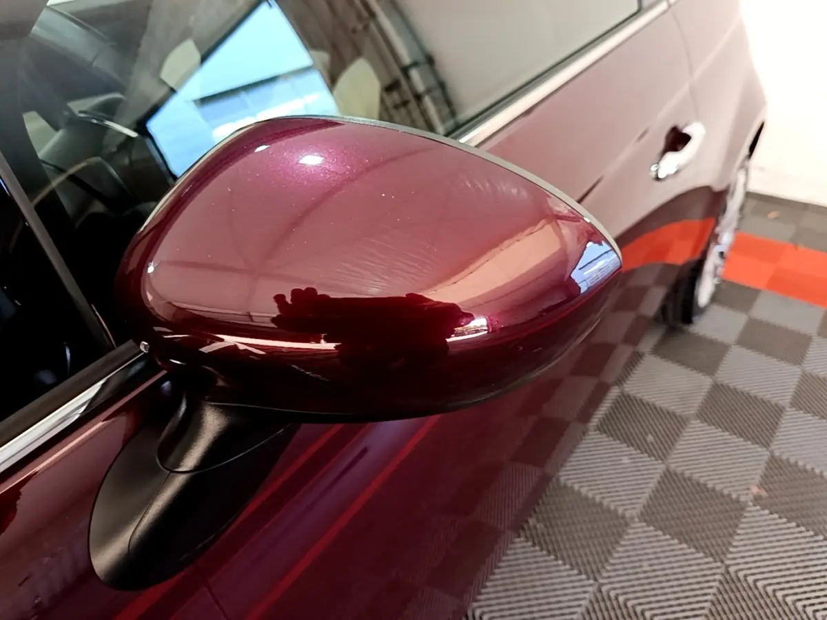 Gros plan sur le rétroviseur côté gauche rouge brillant de la FIAT 500 1.0 70ch BSG Star 2021, avec portière visible.