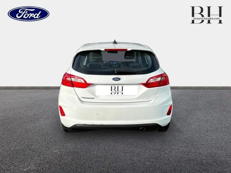 Vue arrière d'une Ford Fiesta blanche Glacier 2020 avec feux arrière rouges et becquet arrière visible.