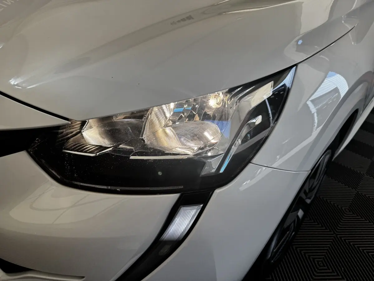 Gros plan sur le phare avant droit blanc brillant de la Peugeot 208 PureTech 100 S&S Active Business 2020.