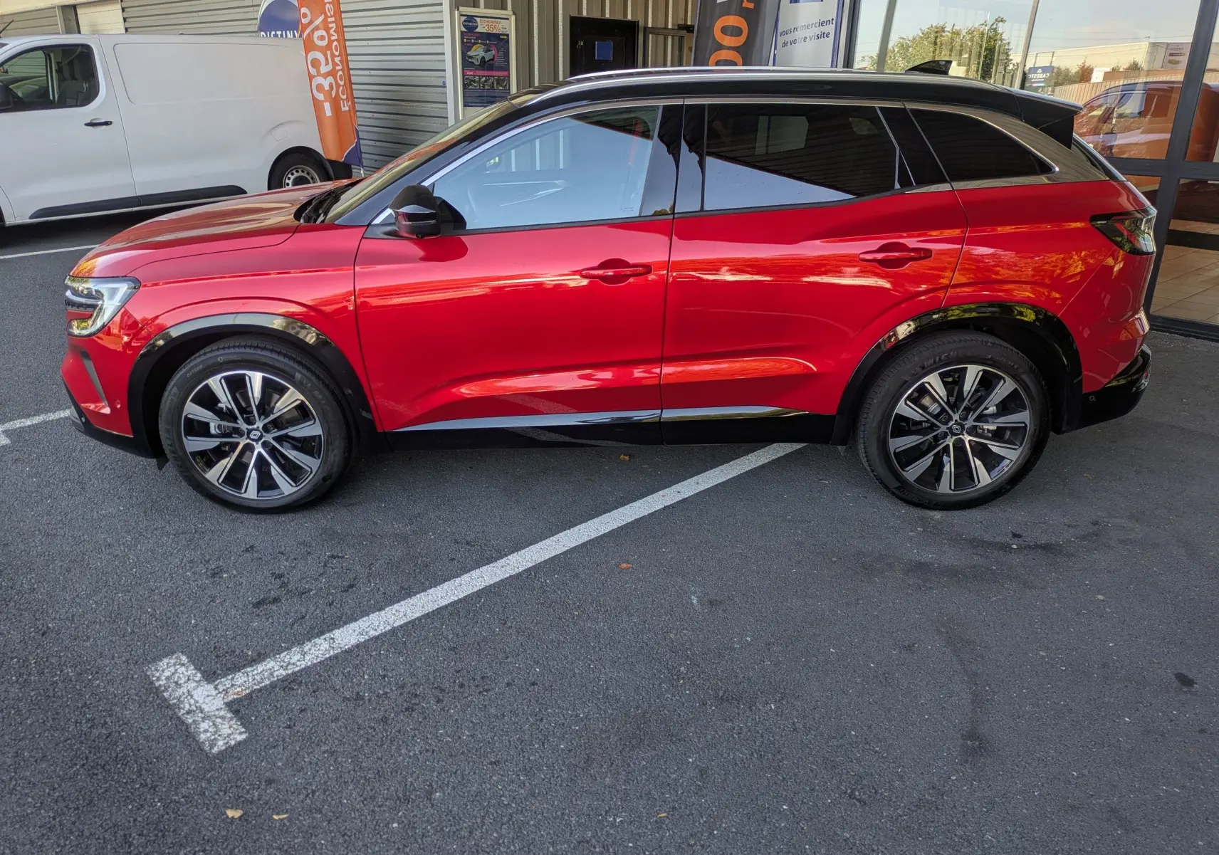 Profil côté gauche du Renault Austral rouge Flamme 2025 avec toit panoramique et jantes bi-ton.