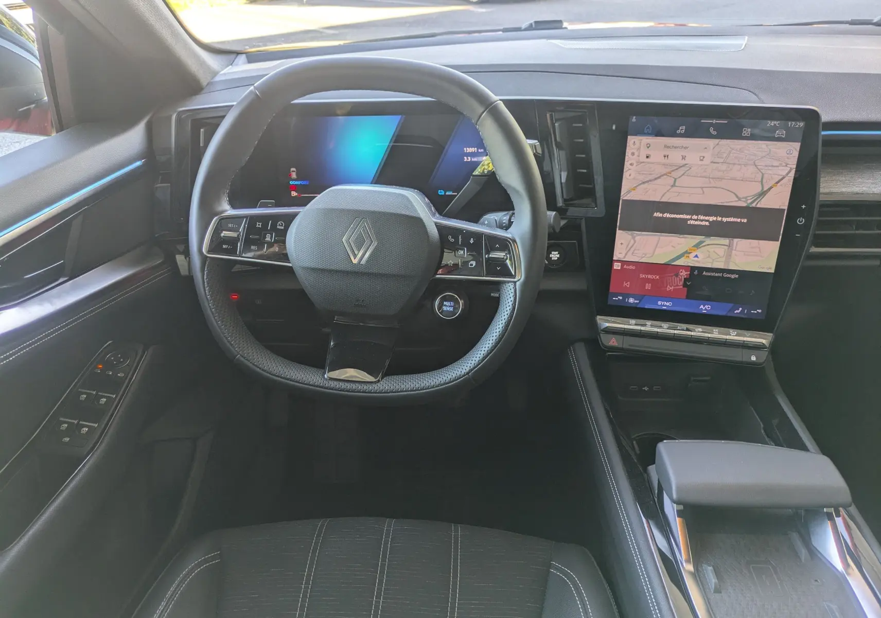 Vue intérieure du poste de conduite du Renault Austral 2025, avec volant multifonction et grand écran tactile central.