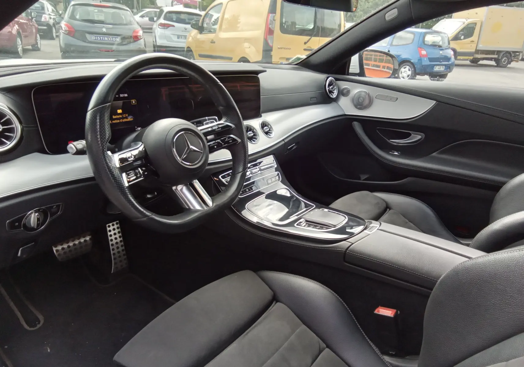 Intérieur noir de la Mercedes Classe E Coupé 220D AMG Line 2020, vue côté conducteur avec tableau de bord et volant visibles.