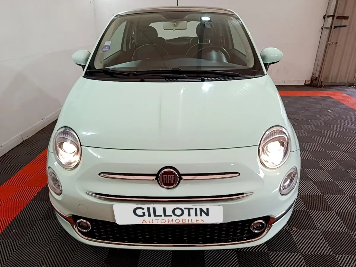 Vue avant d'une Fiat 500 Lounge 2019 vert clair avec phares allumés dans un garage.