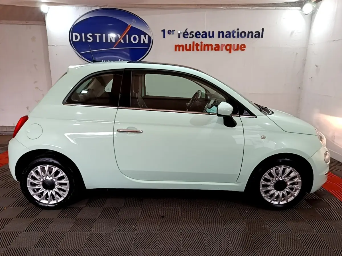 Profil côté gauche d'une FIAT 500 Lounge 2019 vert clair, avec jantes alliage et rétroviseurs blancs.