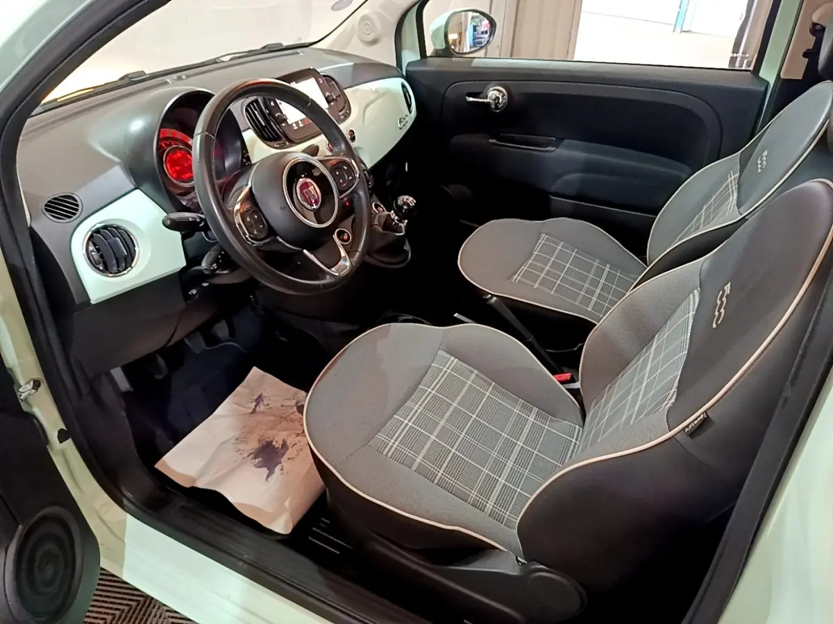 Vue intérieure côté conducteur de la FIAT 500 Lounge 2019 avec sièges gris à motifs et tableau de bord clair.