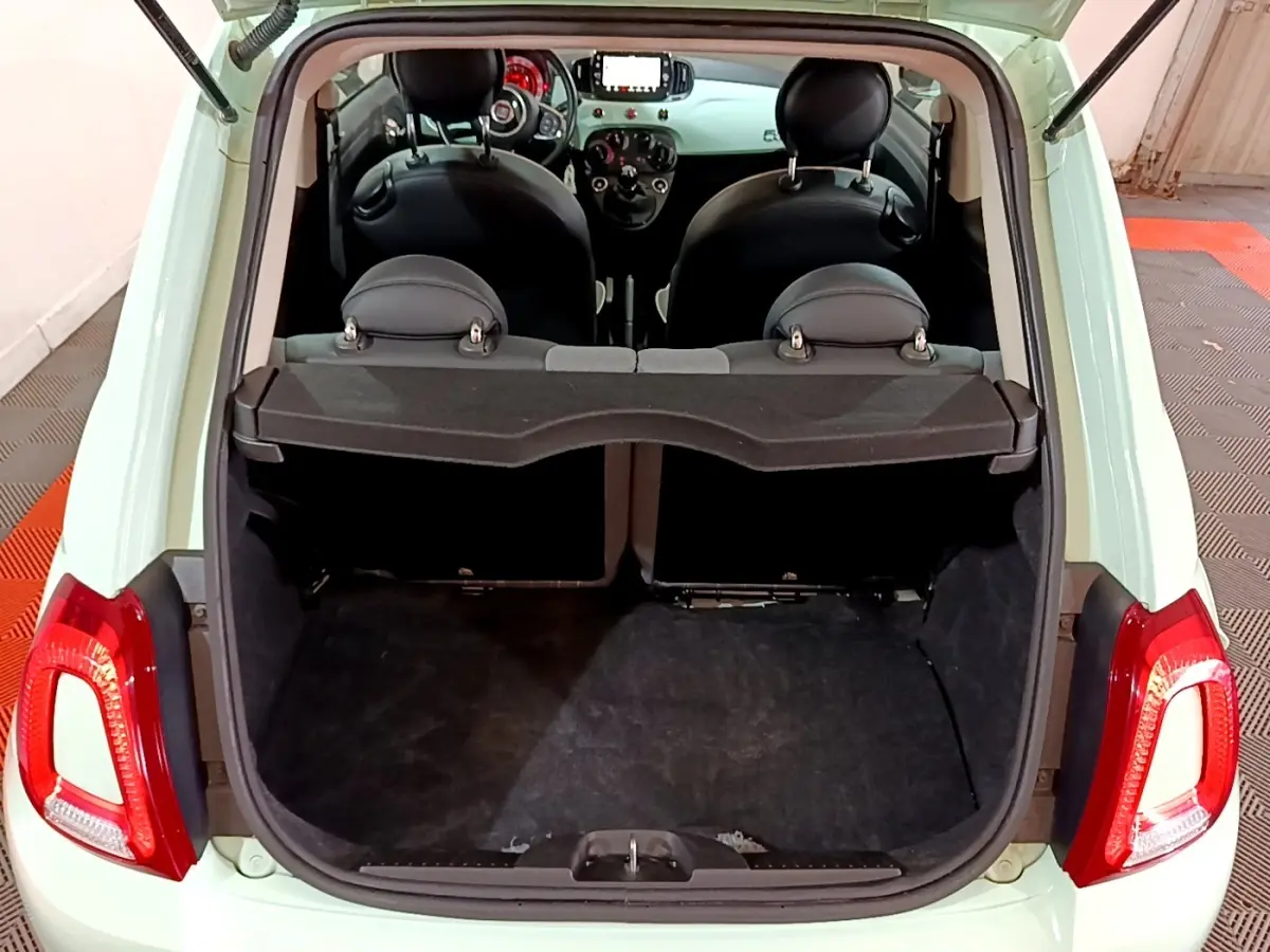 Coffre ouvert vu de l'arrière d'une FIAT 500 Lounge 2019 vert clair, montrant l'habitacle et la tablette de séparation.
