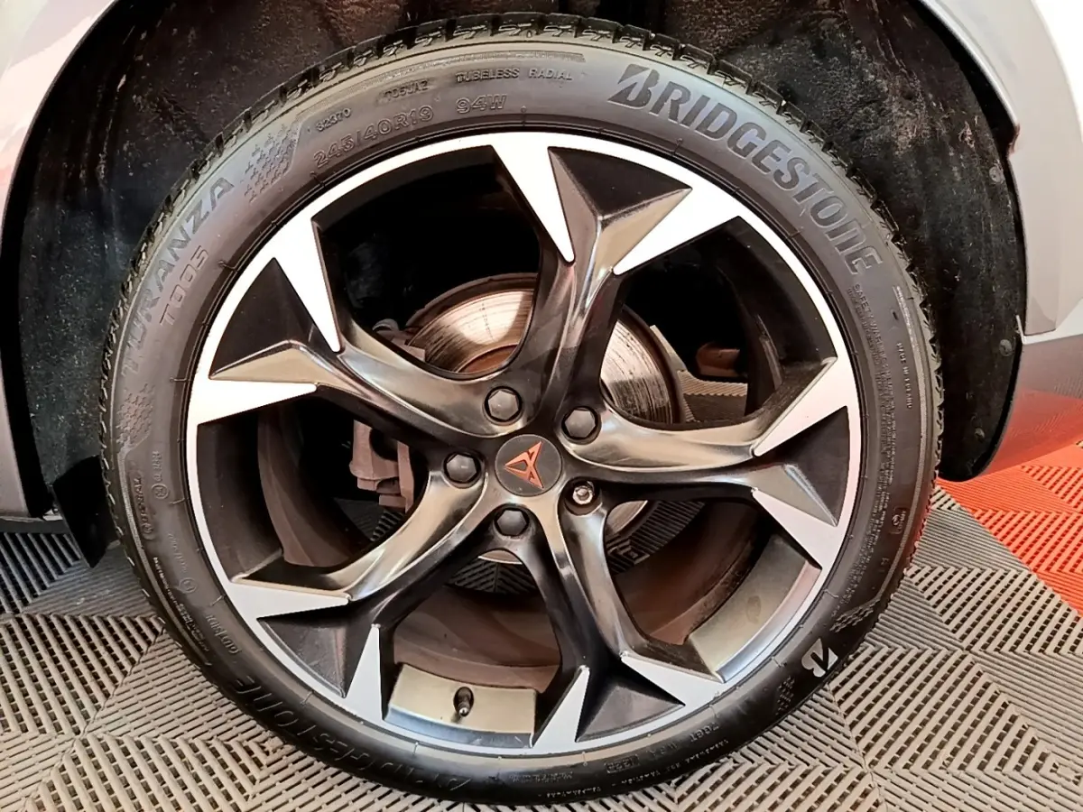 Gros plan sur la jante alliage noire et argentée avec logo CUPRA au centre, montée sur pneu Bridgestone.