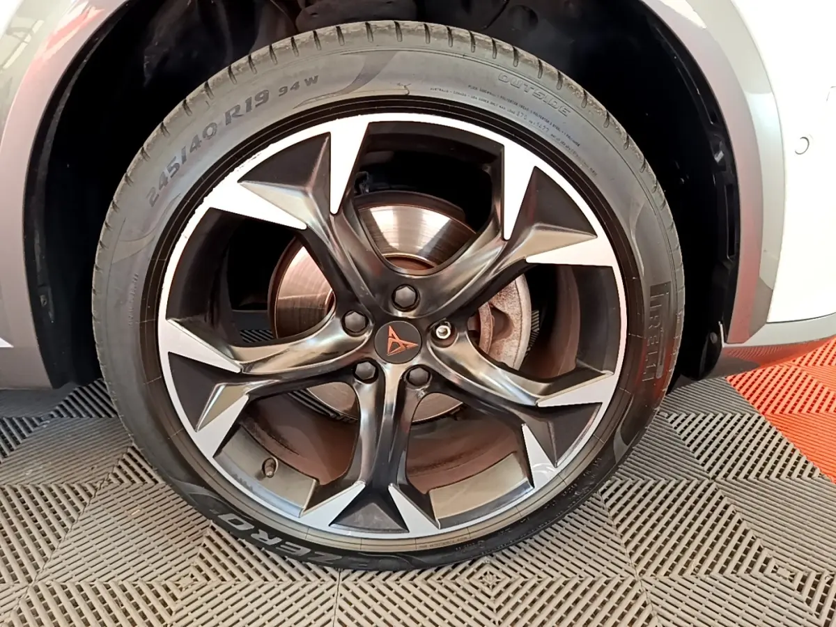 Gros plan sur la roue avant droite d’un CUPRA Formentor 2023 avec jante alliage noire et argentée, logo central visible.