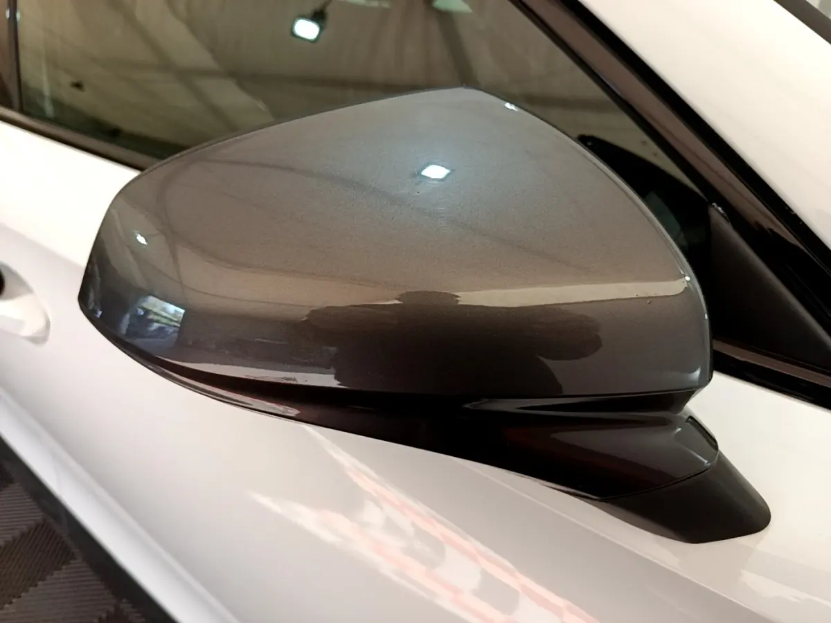 Rétroviseur droit gris métallisé sur CUPRA Formentor 2023 blanc, vue rapprochée en intérieur.