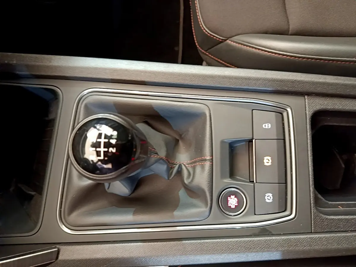 Vue rapprochée de la commande de boîte manuelle noire avec surpiqûres rouges dans une CUPRA Formentor 2023.