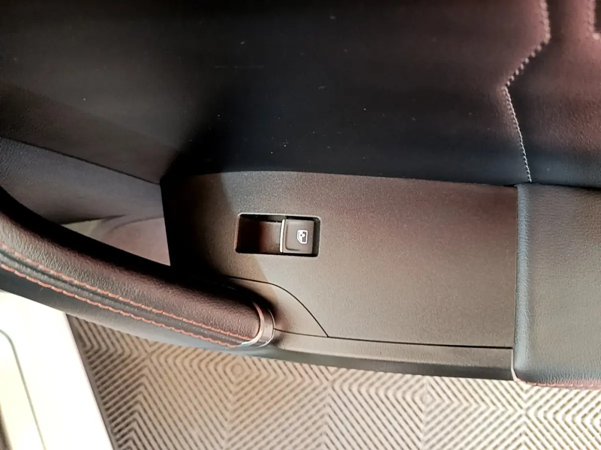 Détail intérieur du levier de frein à main en cuir noir avec surpiqûres rouges du CUPRA Formentor 2023.