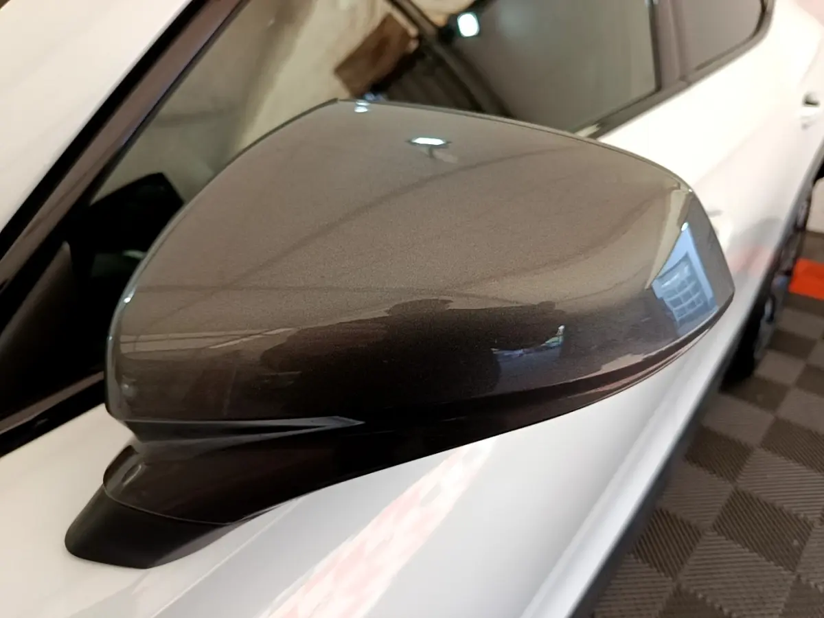 Rétroviseur droit gris métallisé du CUPRA Formentor 2023, avec carrosserie blanche visible en arrière-plan.