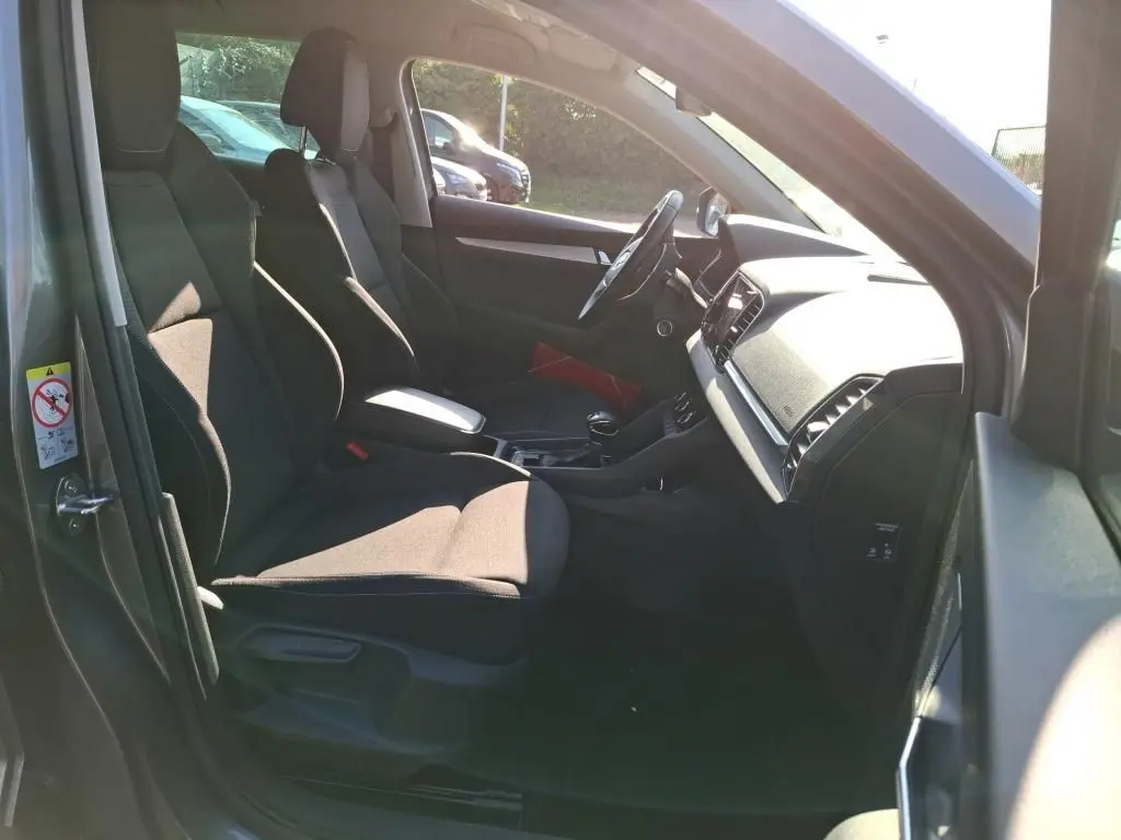 Vue intérieure côté gauche du Skoda Karoq gris 2023, montrant les sièges avant et le tableau de bord.