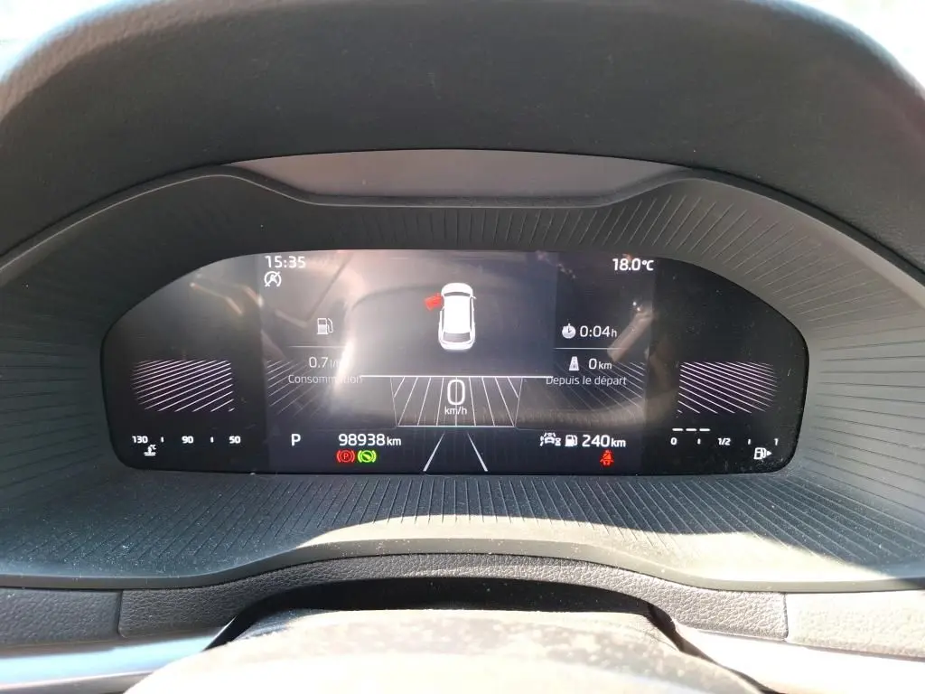 Tableau de bord numérique du Skoda Karoq 2.0 TDI gris, affichant la vitesse à 0 km/h et l'autonomie à 240 km.