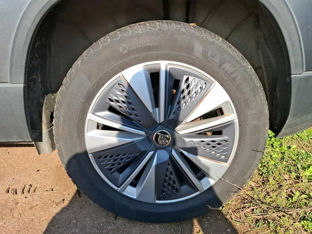 Gros plan sur la jante alu 17 pouces gris argent avec logo Skoda, montée sur un pneu Michelin d’un Skoda Karoq gris.