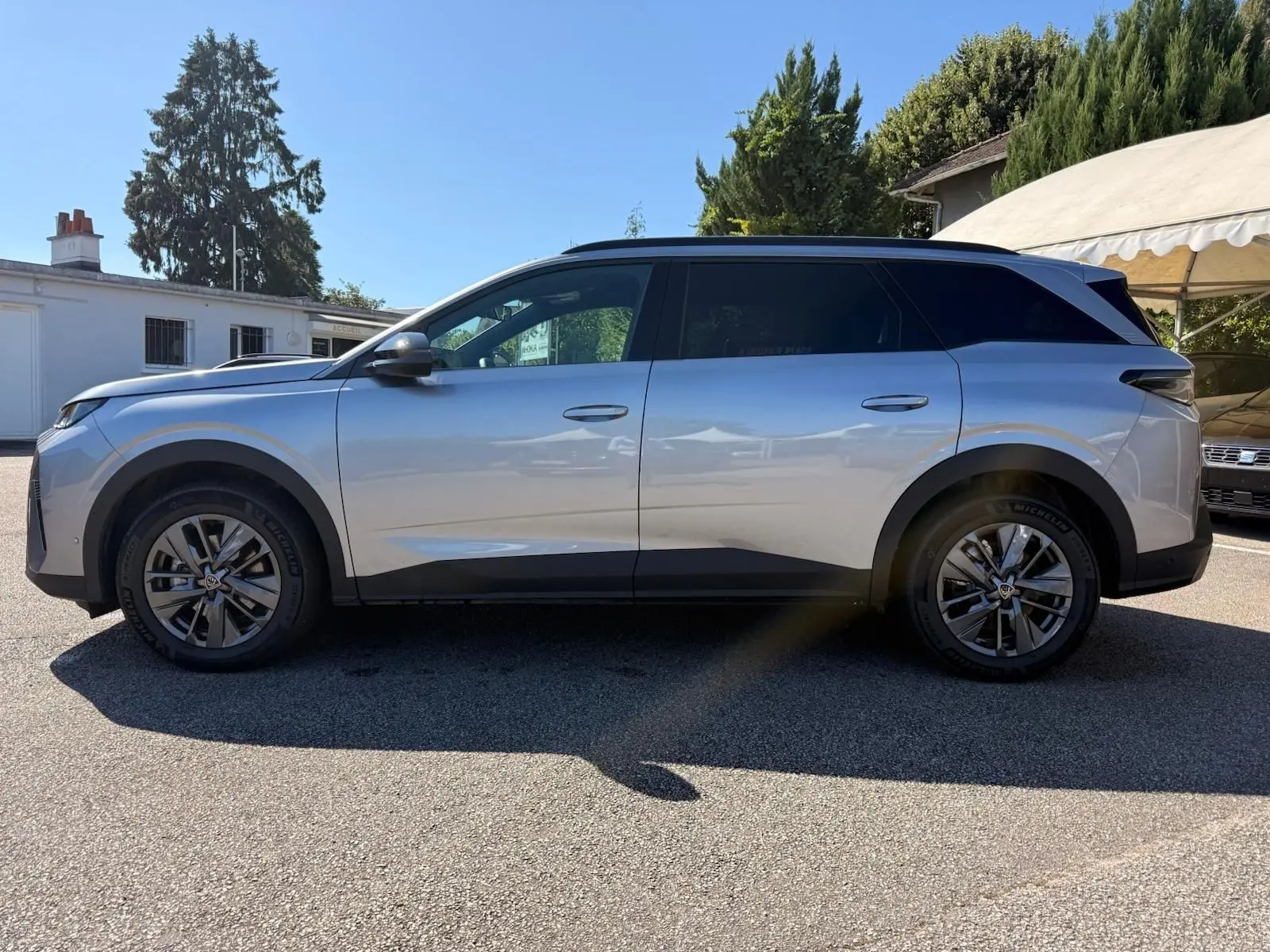 Vue de profil côté gauche d’un Peugeot 5008 gris Artense 2025 avec jantes alliage et vitres teintées.