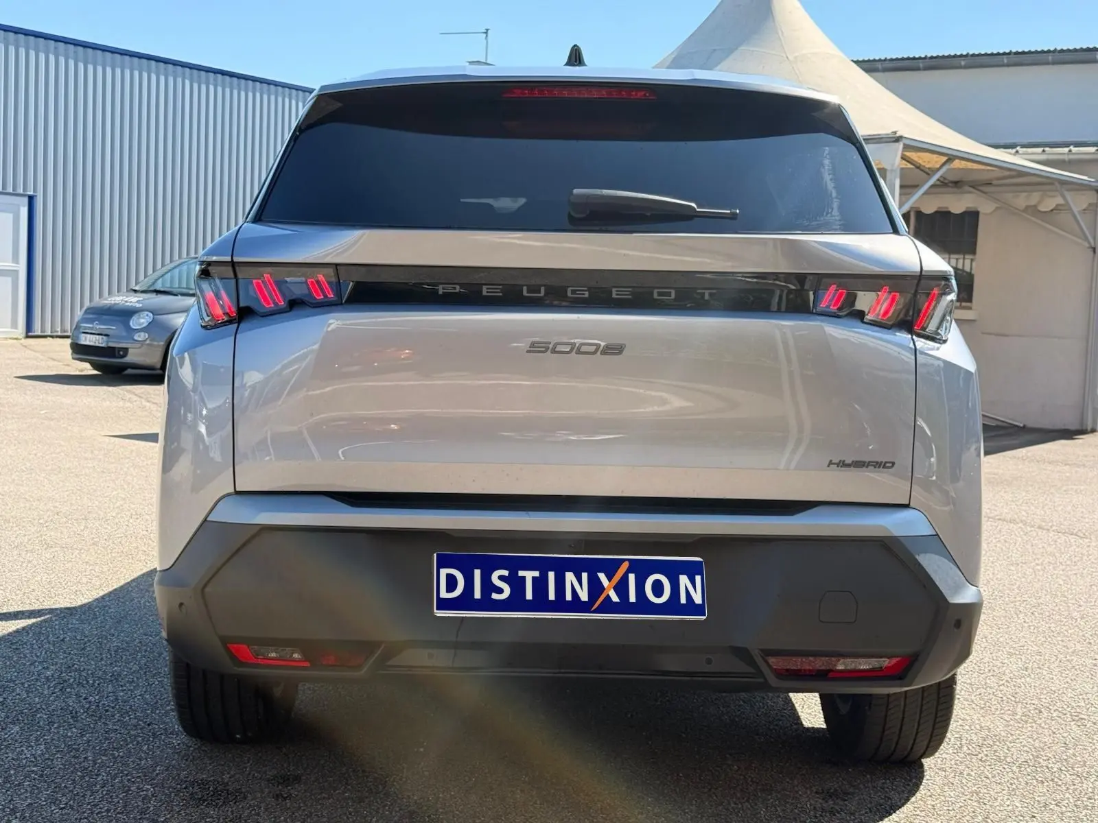 Vue arrière d’un Peugeot 5008 gris Artense hybride 2025 avec feux arrière LED distinctifs et vitrage teinté.