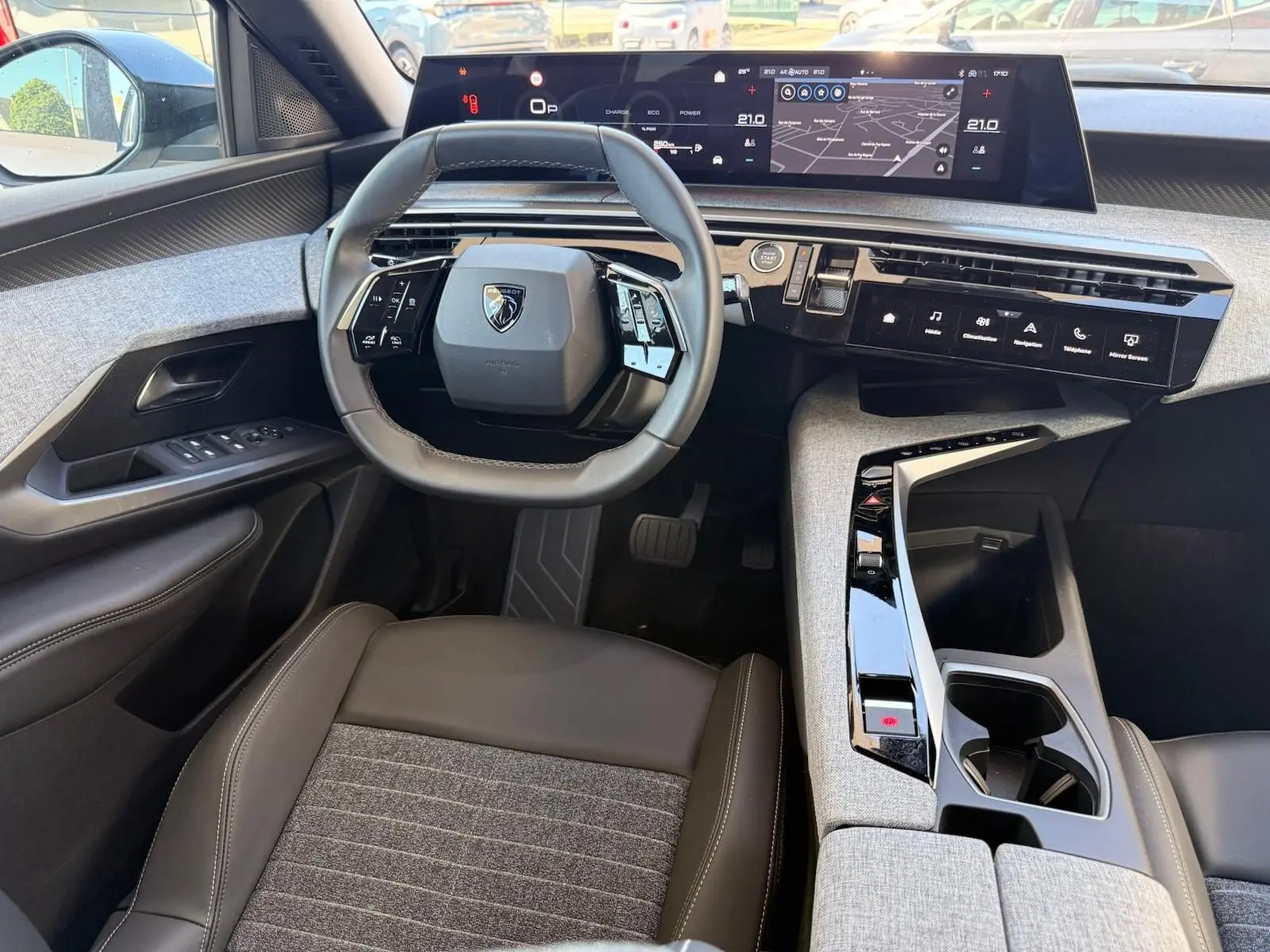 Vue intérieure de face du poste de conduite du Peugeot 5008 2025, volant compact et tableau de bord numérique large.