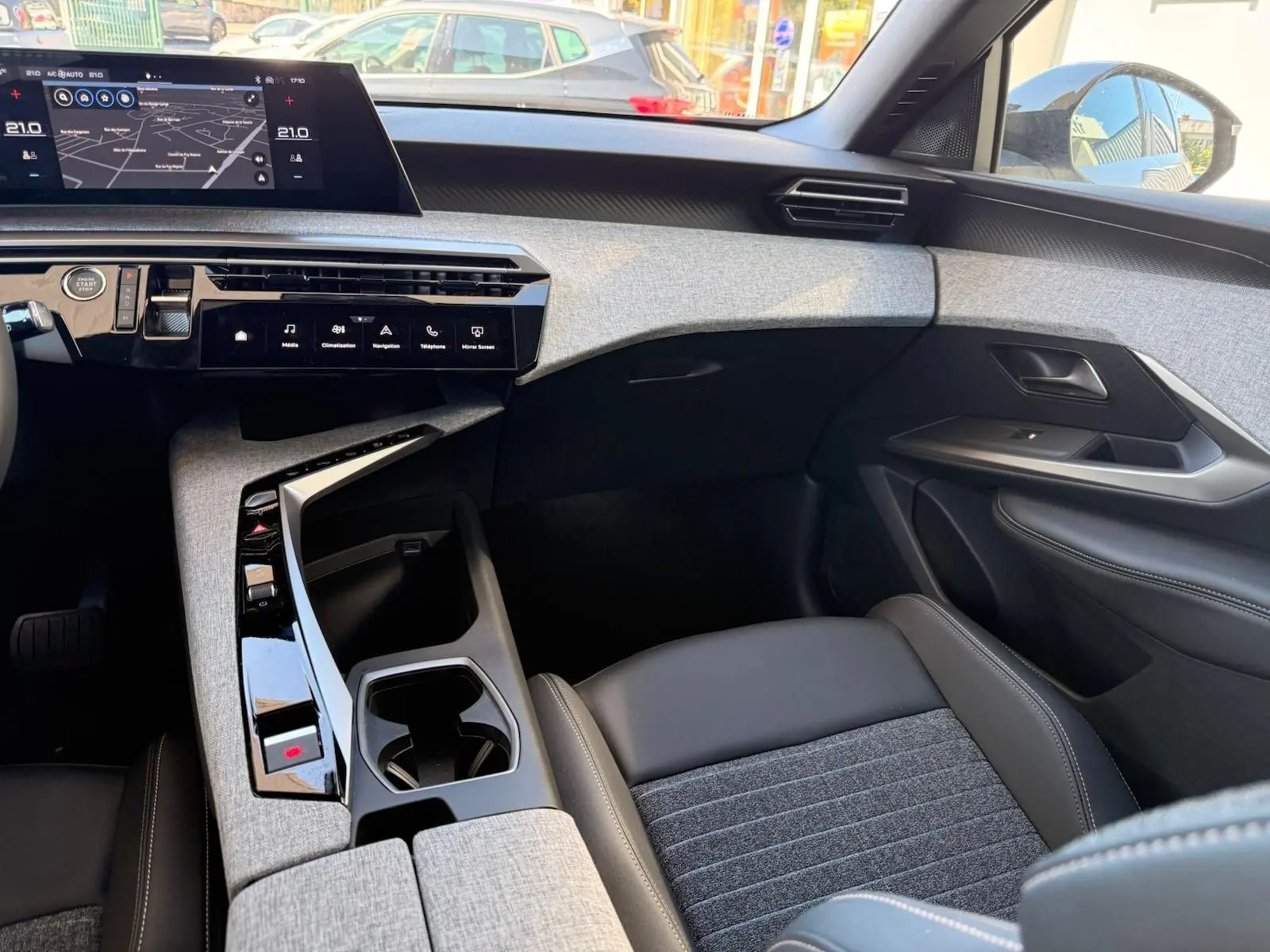 Intérieur du Peugeot 5008 2025 en gris Artense, vue côté passager mettant en valeur la console centrale et l’écran tactile.