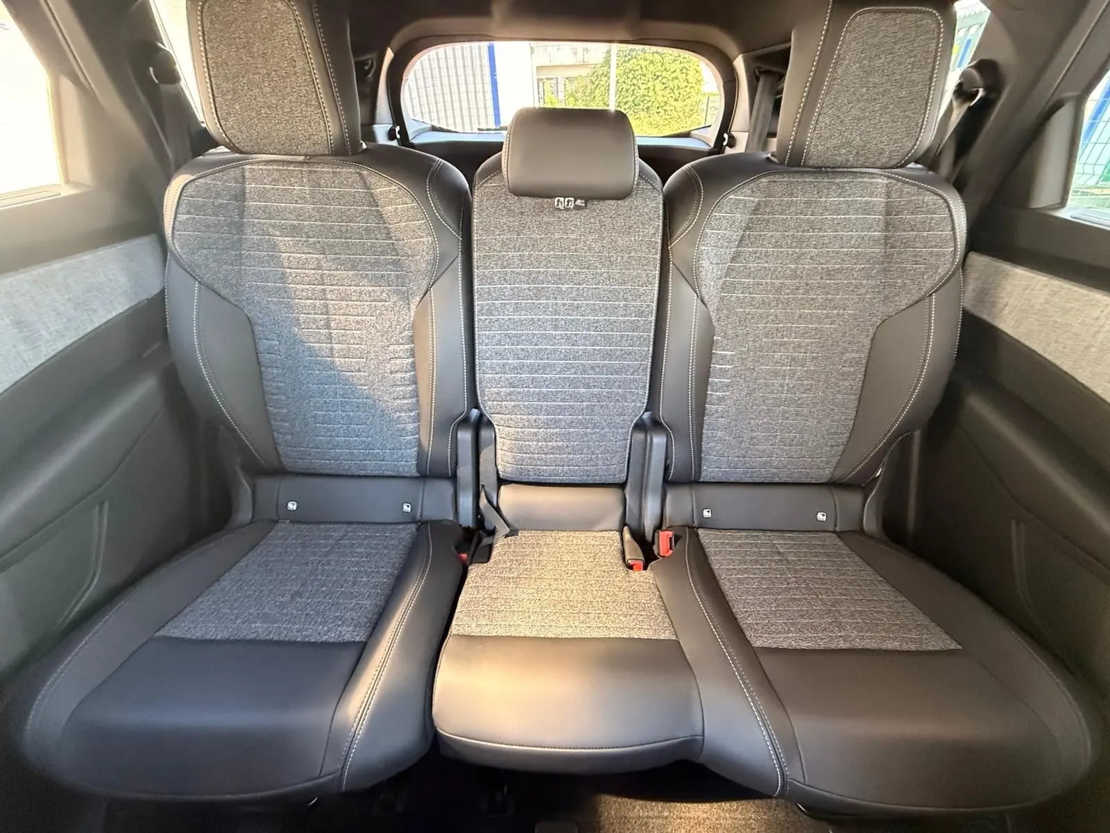 Vue arrière des sièges arrière en tissu gris et cuir noir du Peugeot 5008 1.2 Hybrid 145 Allure 2025.