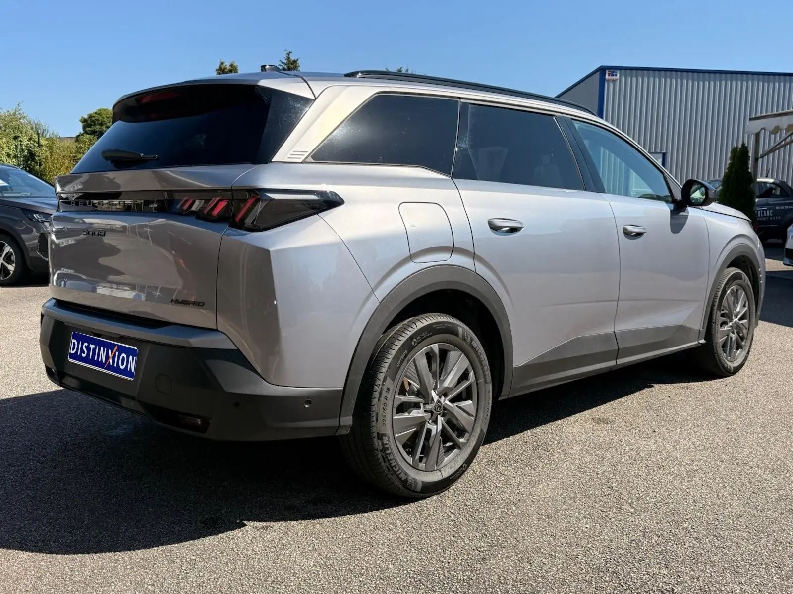 Peugeot 5008 gris Artense en vue 3/4 arrière droit, mettant en valeur ses lignes modernes et ses feux arrière LED distinctifs.