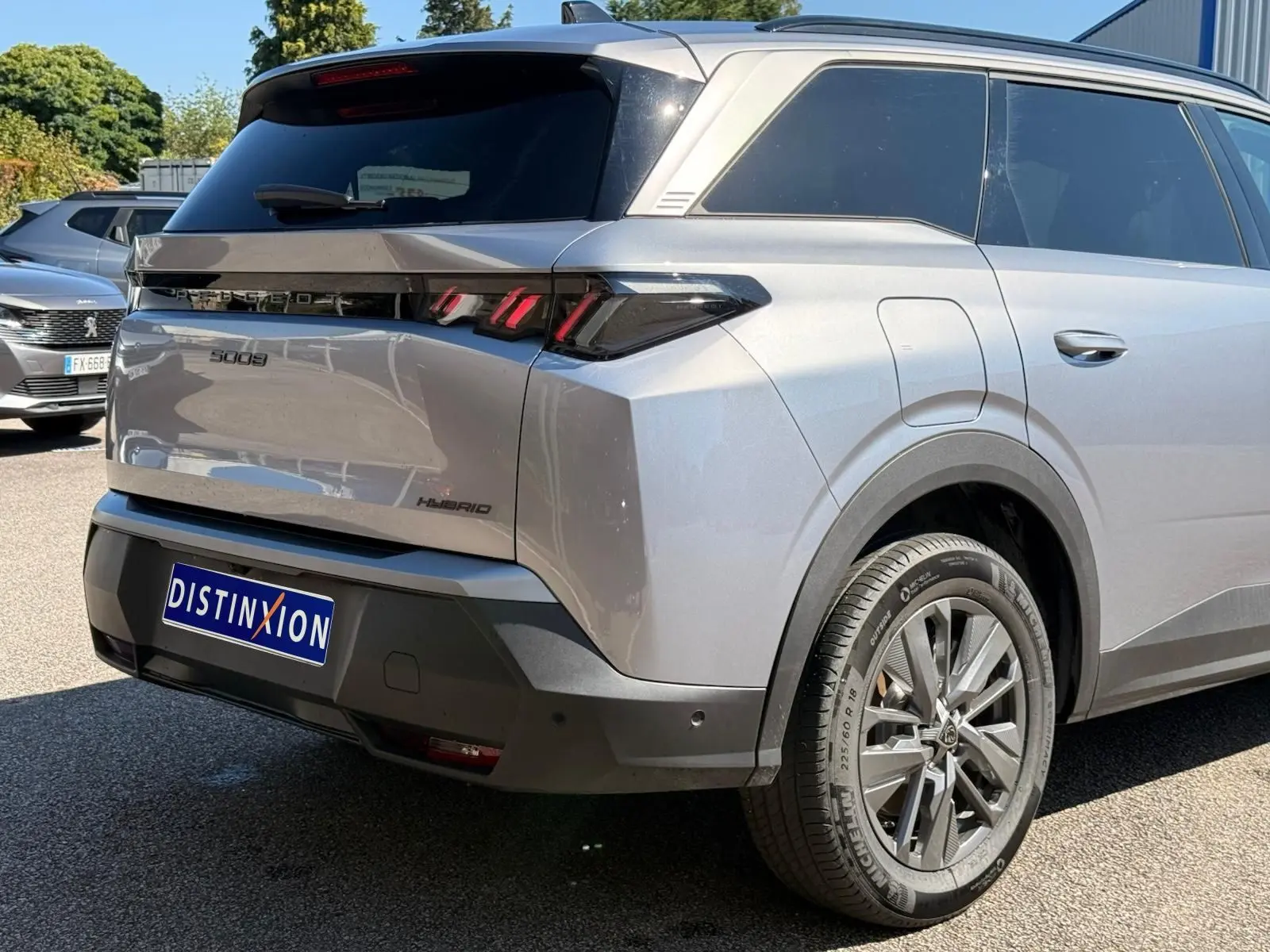 Vue 3/4 arrière droite du Peugeot 5008 gris Artense hybride 2025 avec feux arrière LED et jantes alliage.