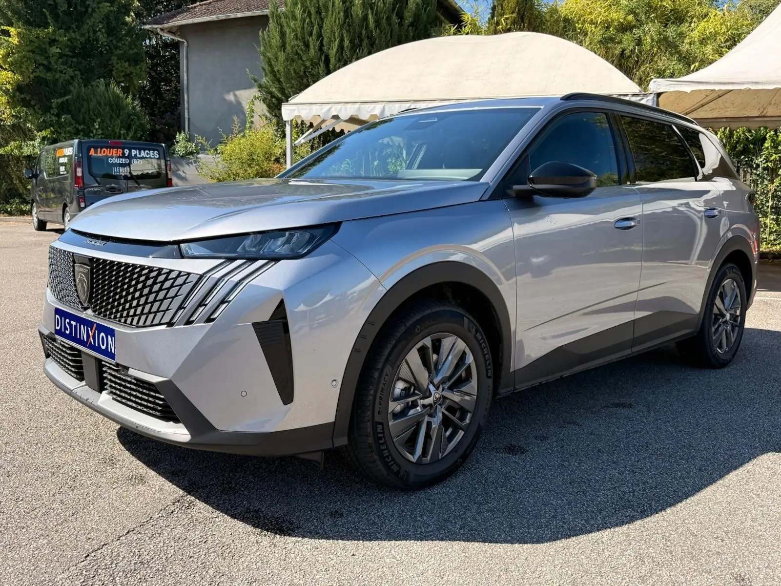 Peugeot 5008 gris Artense en vue 3/4 avant droit, avec calandre distinctive et jantes alliage modernes.
