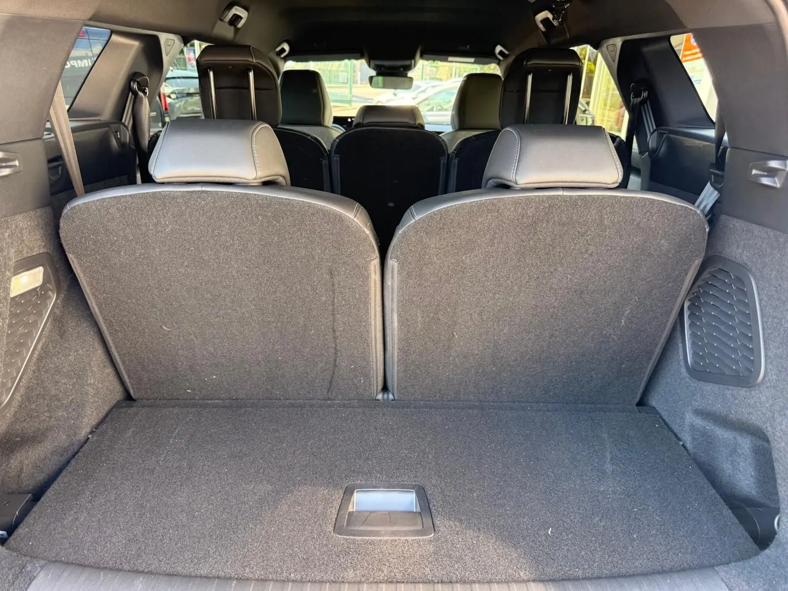 Vue depuis le coffre du Peugeot 5008 gris Artense 2025, montrant les sièges arrière relevés et l'espace de chargement.