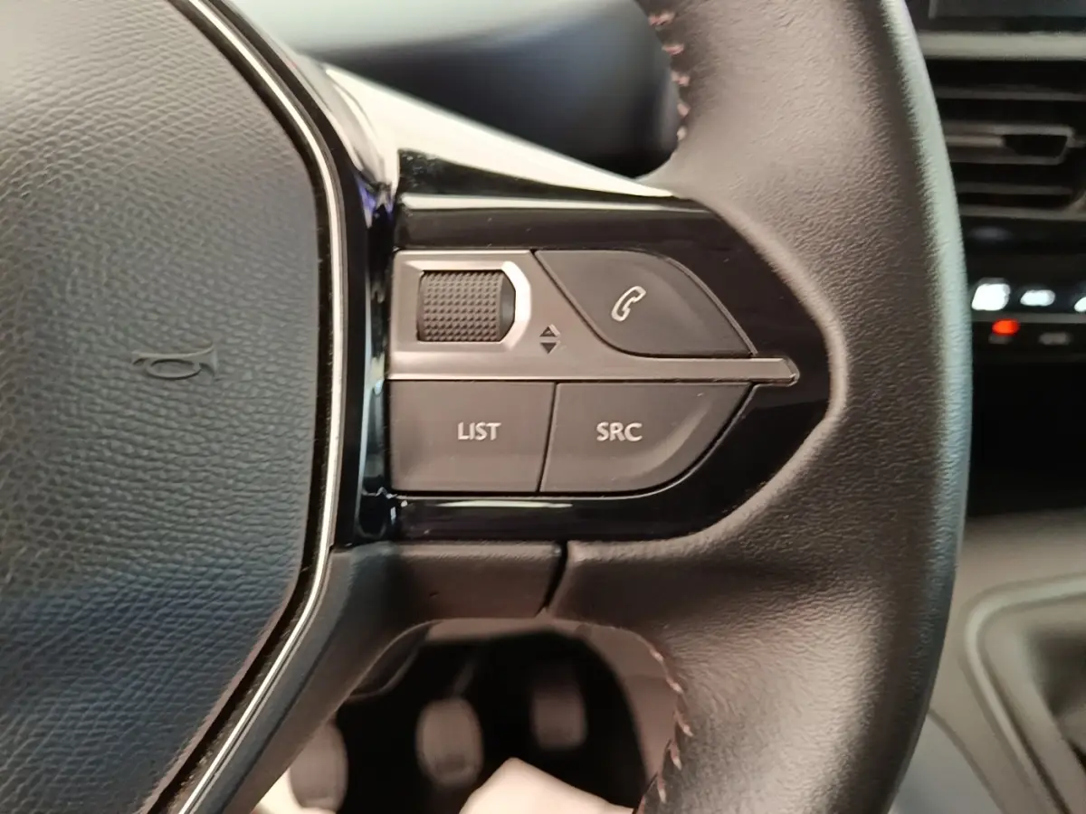 Gros plan sur le volant cuir multifonctions du Peugeot Rifter 2020, avec commandes audio et téléphone intégrées.