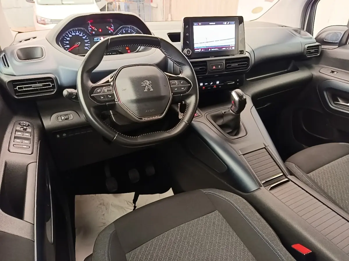 Vue intérieure avant du Peugeot Rifter 2020, volant cuir multifonctions et écran tactile central visible.