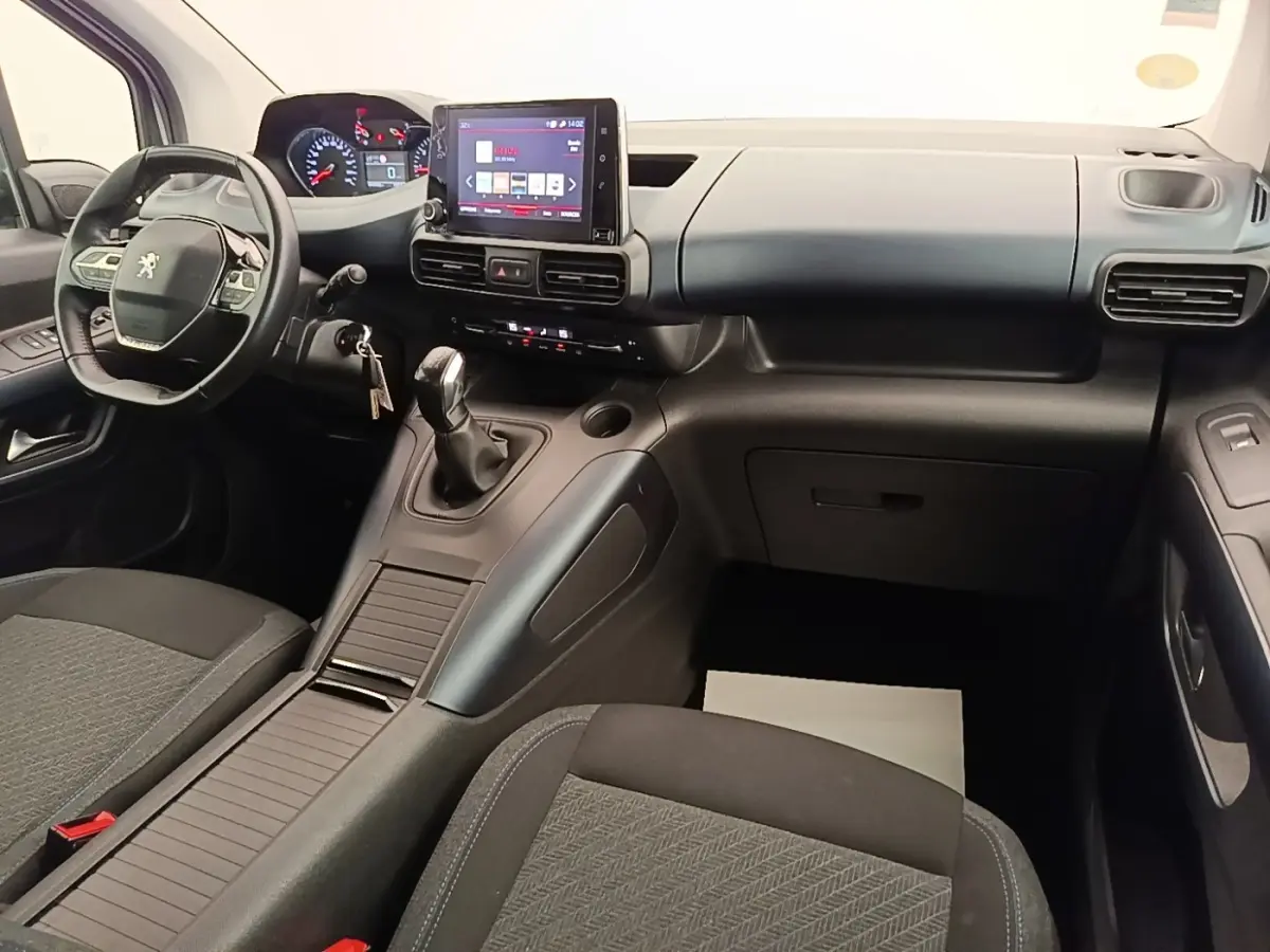 Vue intérieure avant du Peugeot Rifter 2020, tableau de bord noir avec écran tactile et volant cuir multifonctions.