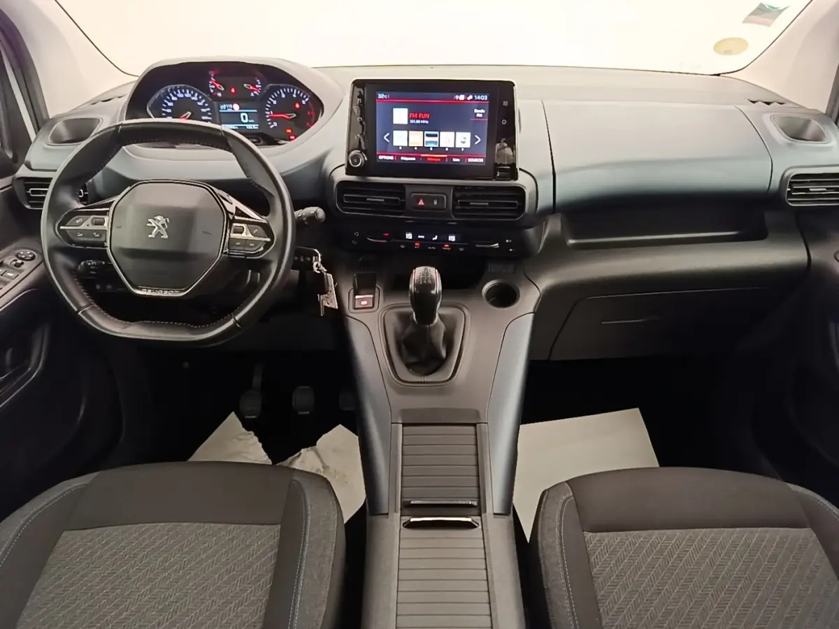 Vue intérieure avant du Peugeot Rifter 2020 avec tableau de bord moderne, volant cuir multifonctions et écran tactile central.