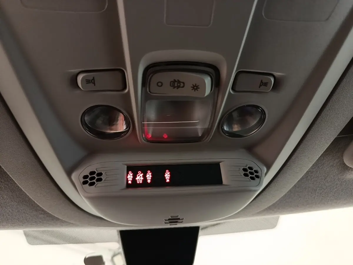 Vue intérieure du plafonnier du Peugeot Rifter blanc 2020 avec commandes d’éclairage et indicateurs de ceinture allumés.