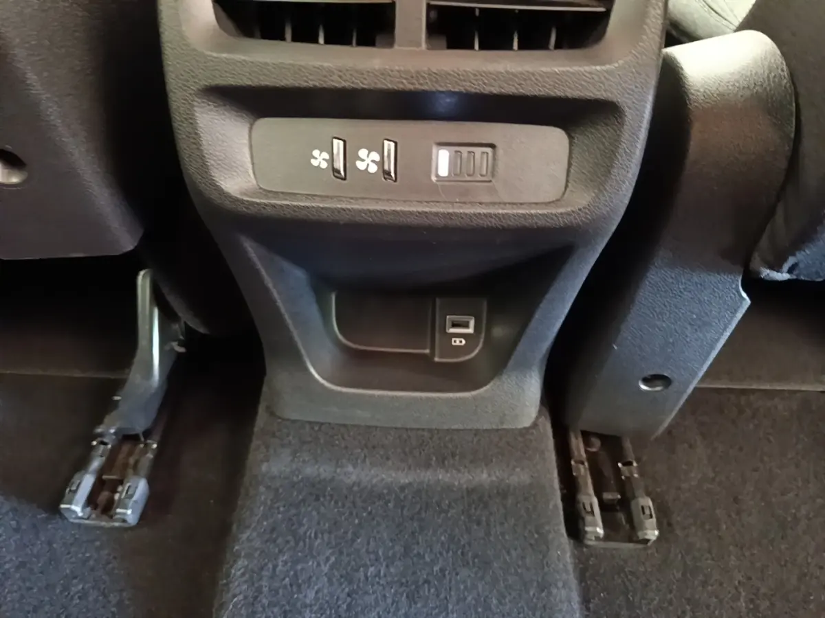 Vue rapprochée de la console centrale arrière du Peugeot Rifter blanc 2020, avec commandes ventilation et prise USB.