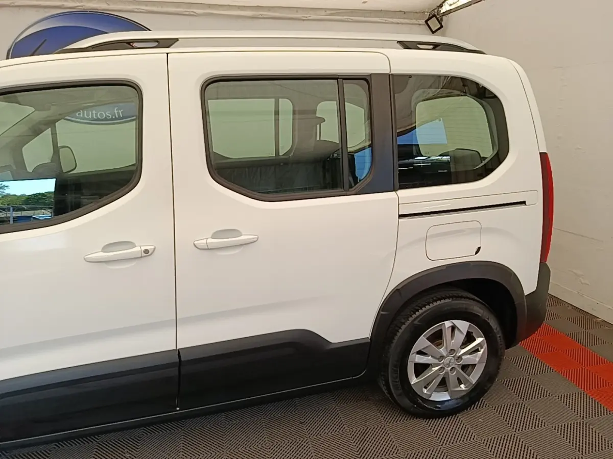 Vue latérale droite d’un Peugeot Rifter blanc 2020 avec portes coulissantes et jantes alliage visibles.