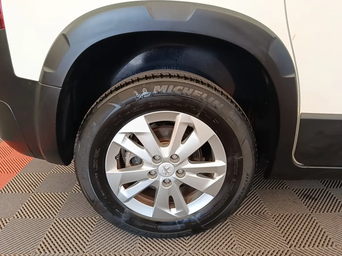 Gros plan sur la roue avant droite du Peugeot Rifter blanc, avec jante alliage et pneu Michelin visible.