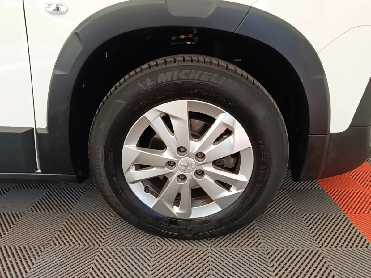 Gros plan sur la roue avant droite d’un Peugeot Rifter blanc avec jante alliage et pneus Michelin.