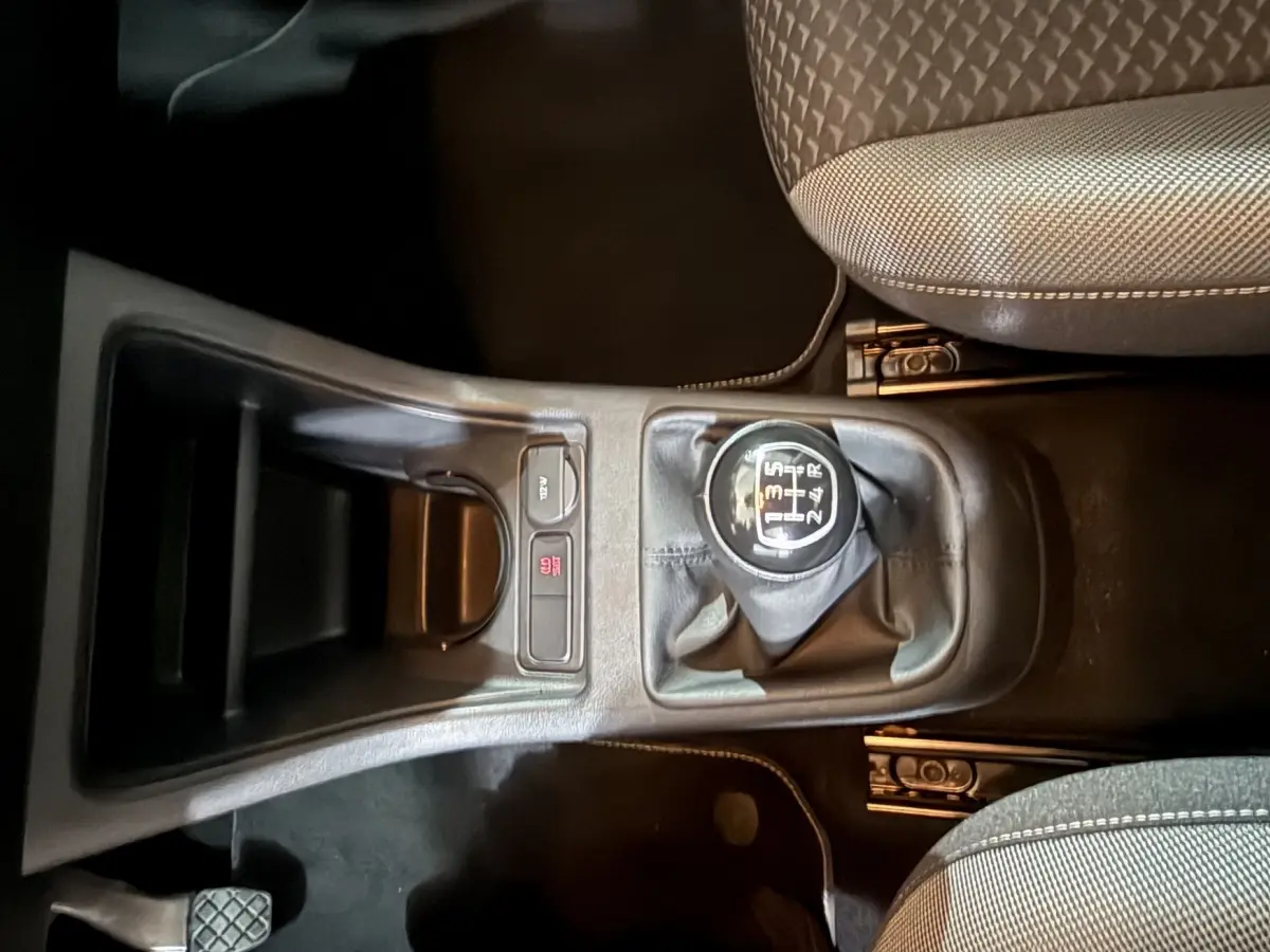 Vue plongeante sur la console centrale du Volkswagen Up 1.0 65 Active 2022, avec levier de vitesse manuel et sièges tissu gris.