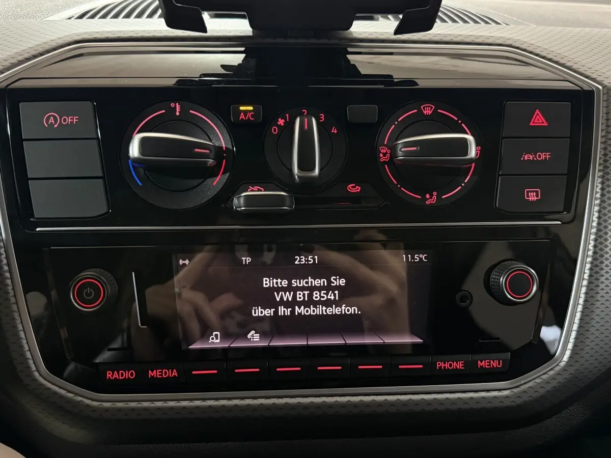 Tableau de bord noir du Volkswagen Up 1.0 65 Active 2022 avec commandes climatisation et écran central allumé.