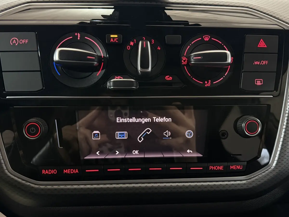 Tableau de bord de Volkswagen Up 1.0 65 Active 2022 avec commandes climatisation et écran tactile central allumé.